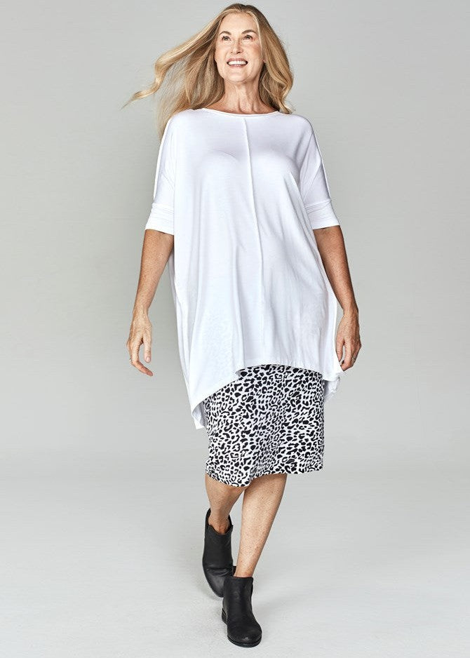 A beautiful older woman wearing a white bamboo tunic top, animal printed midi skirt and a black boots (Product image)