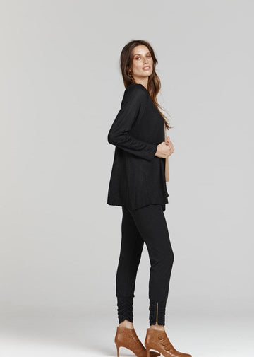 A woman wearing a black cardigan, black skinny pants and a pair of brown high heel boots (Product image)