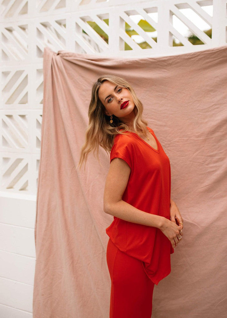 A confident woman wearing Lou Lou's V Neck Bamboo Top matching with a red lipstick