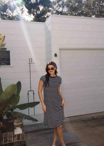 Woman wearing Lou Lou's Striped Black & White Bamboo Dress paired with a black sunglasses outdoor