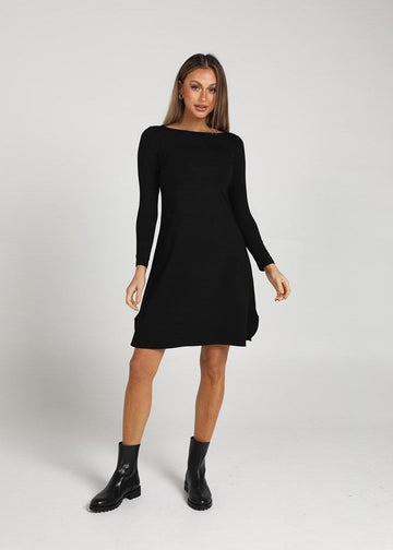 Katie Shannon wearing a black long sleeve t-shirt dress and a pair of black boots