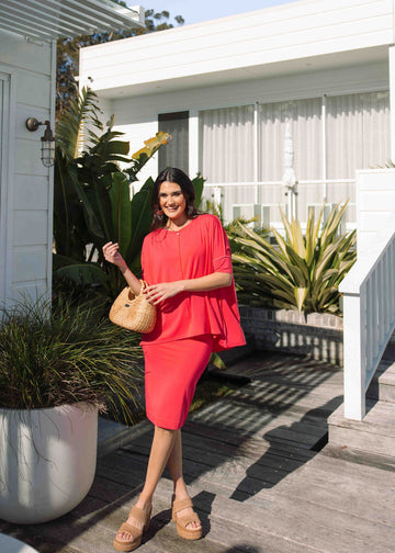 Confident woman wearing Lou Lou's Oversized Bamboo Tee with matching midi skirt, brown sandals and a brown handbag outside