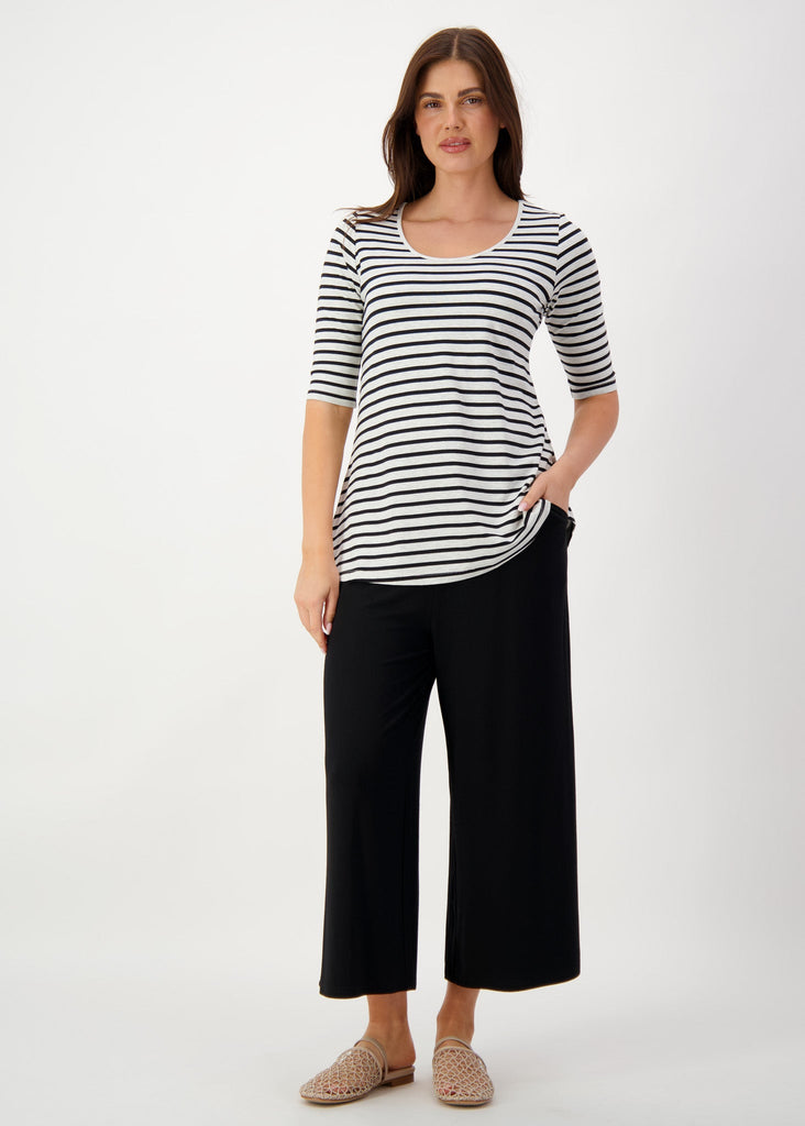 The model is wearing a black and white striped top and a relaxed black pants with a flat brown sandals (Product image)