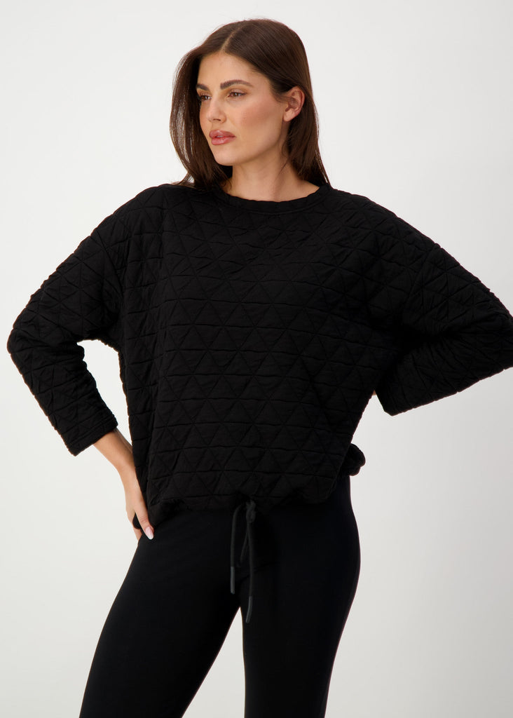 A woman modelling while wearing a black longsleeve top and a black pants (Product image)